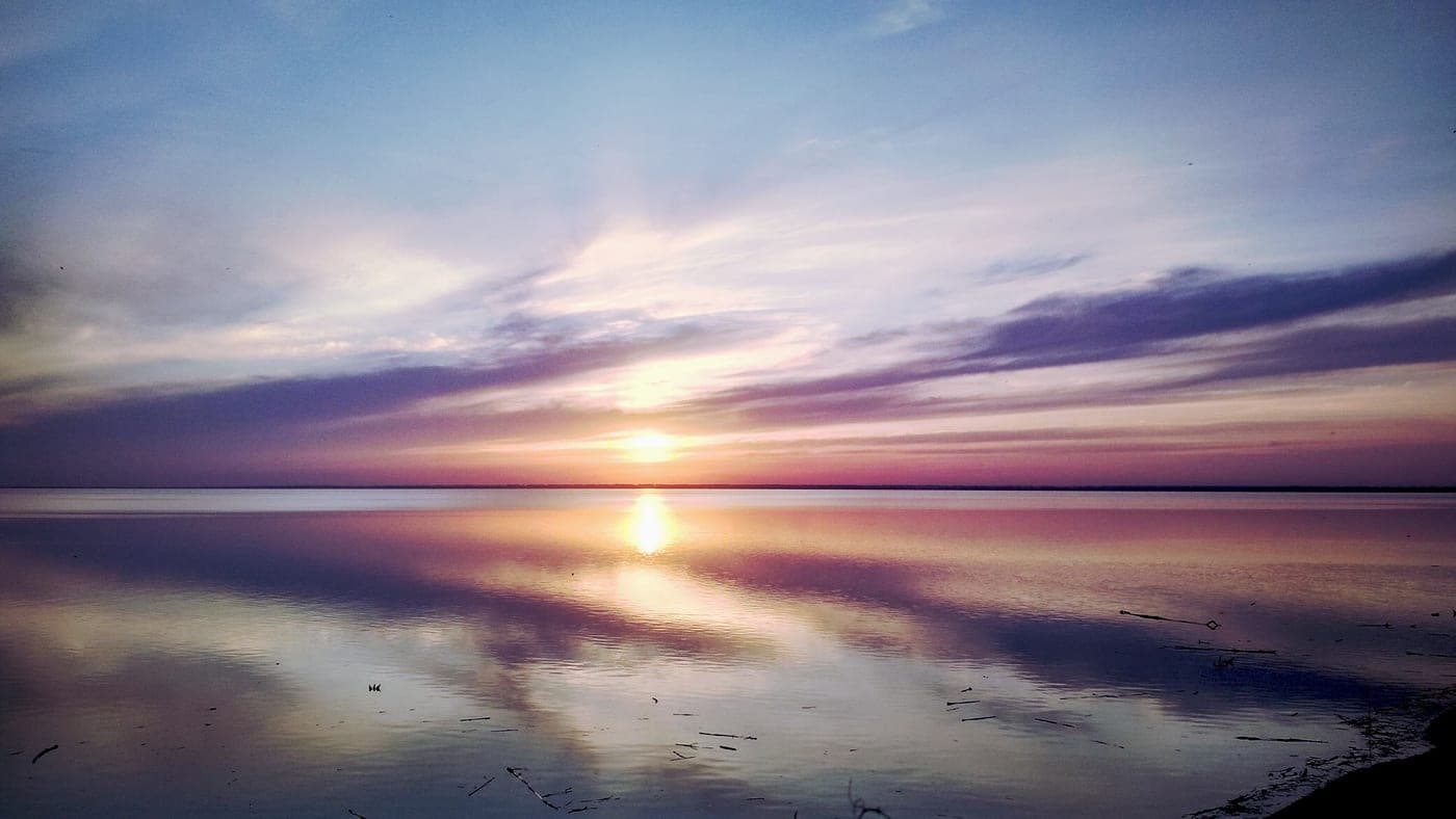 Calm water along the shoreline of a Kansas reservoir at golden hour