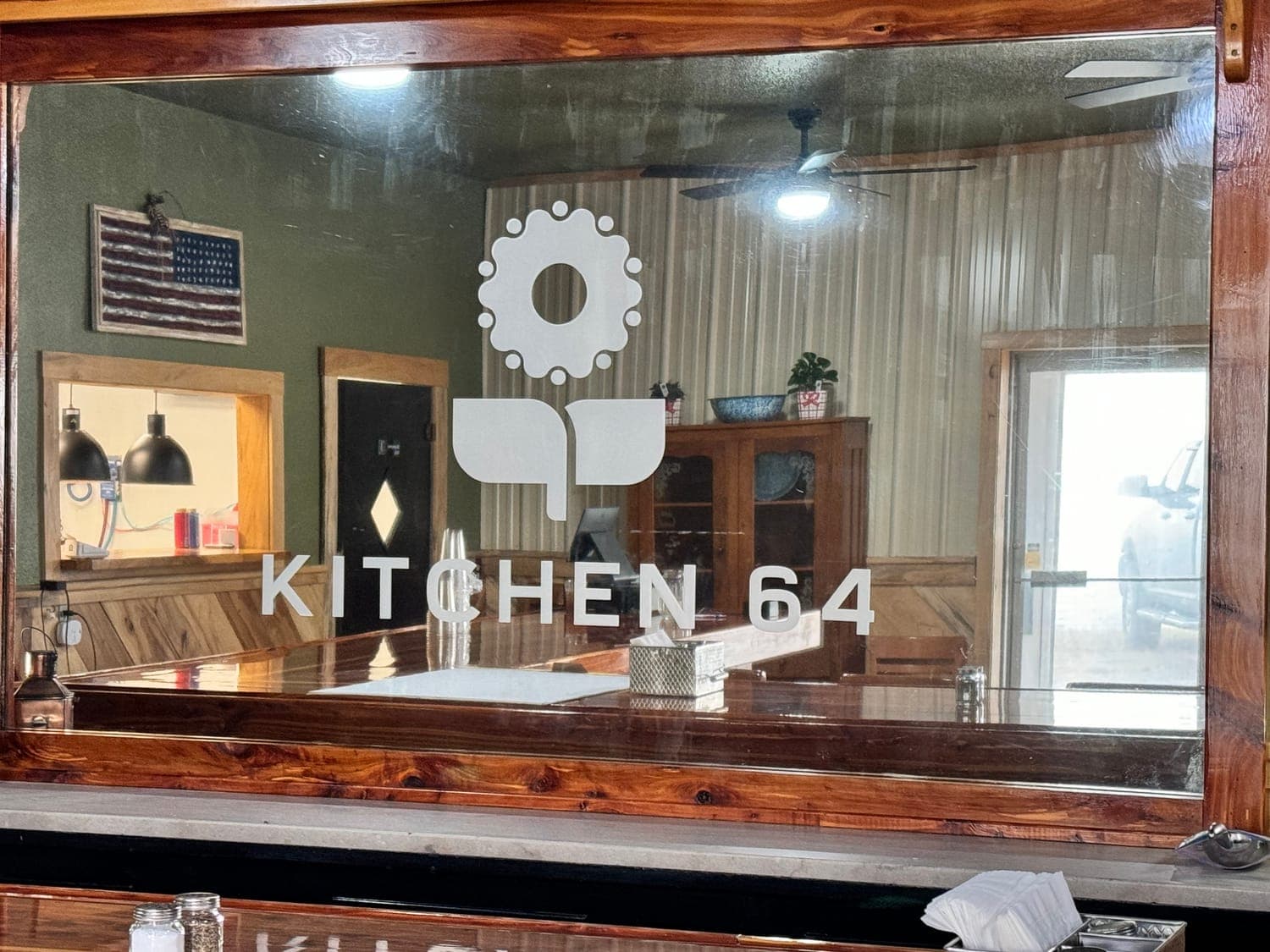 The Kitchen 64 logo etched into the cedar-framed mirror inside the Marquette dining room